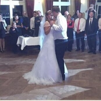 DJ Neustrelitz sorgt für Stimmung beim Hochzeitstanz – Brautpaar tanzt vor Familie Brautpaar tanzt den Hochzeitstanz, während Familie und Freunde im Hintergrund zuschauen – DJ Neustrelitz begleitet die Hochzeitsfeier musikalisch
