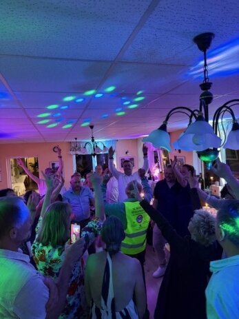 DJ Berlin sorgt für ausgelassene Stimmung auf Hochzeitsparty Jubelnde Gäste tanzen und feiern auf einer Hochzeitsparty mit DJ in Berlin